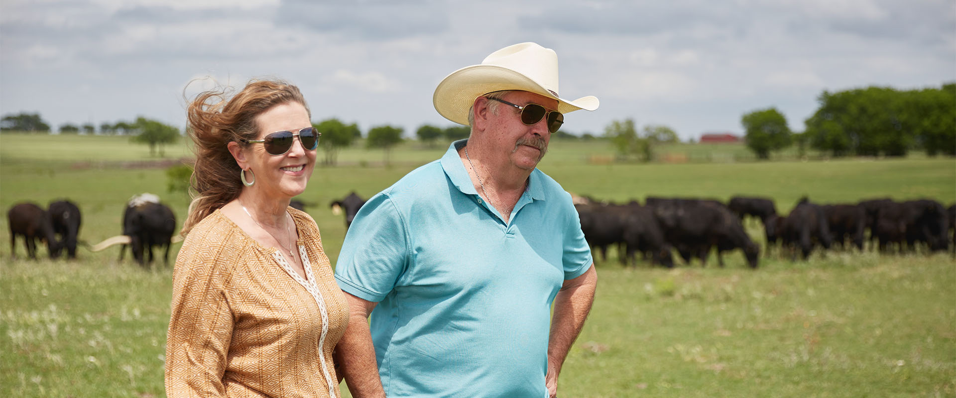 man and women outside in cow pasture 